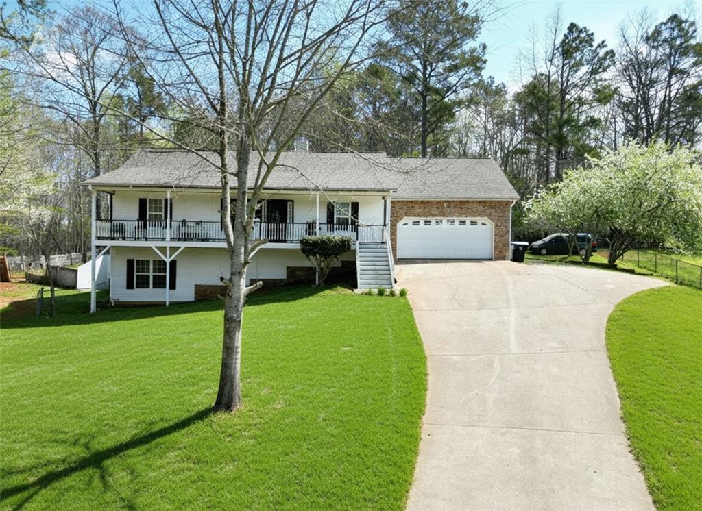 a front view of a house with a garden and trees