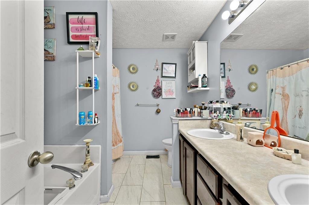 125 Tricias Way Temple, GA 30179 - Photo 18 of 39 a bathroom with a granite countertop sink a mirror a bathtub and shower
