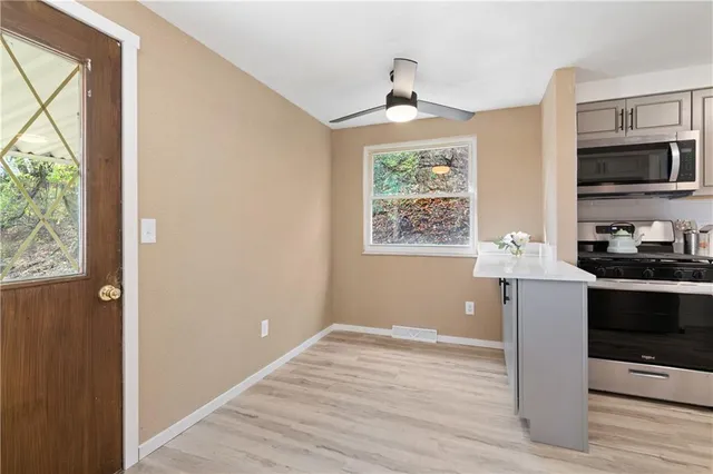 a kitchen with granite countertop a stove a sink and a microwave