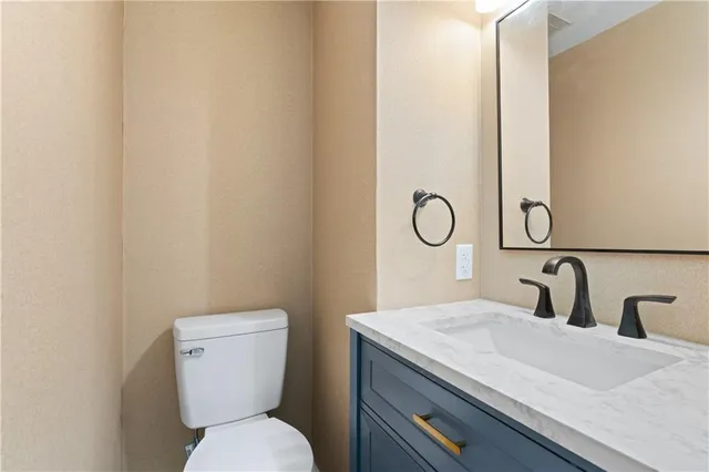 a bathroom with a toilet a sink and mirror