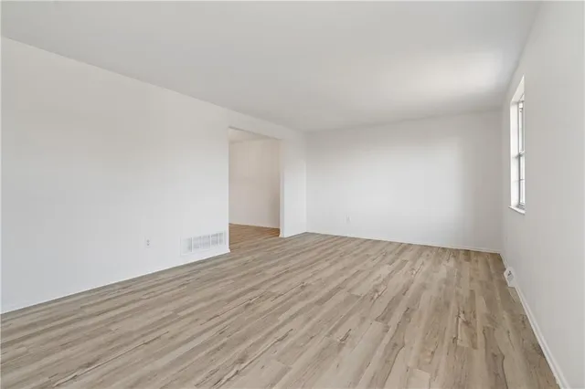 a view of an empty room and wooden floor