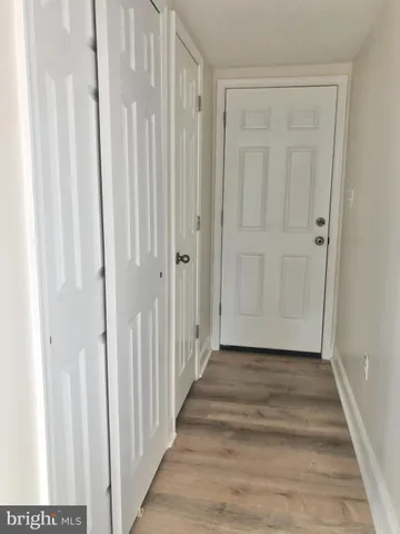 a view of a hallway with wooden floor