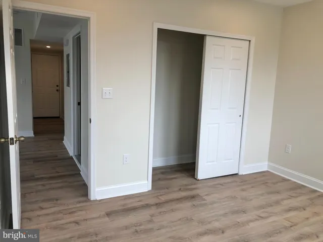 an empty room with wooden floor and entryway