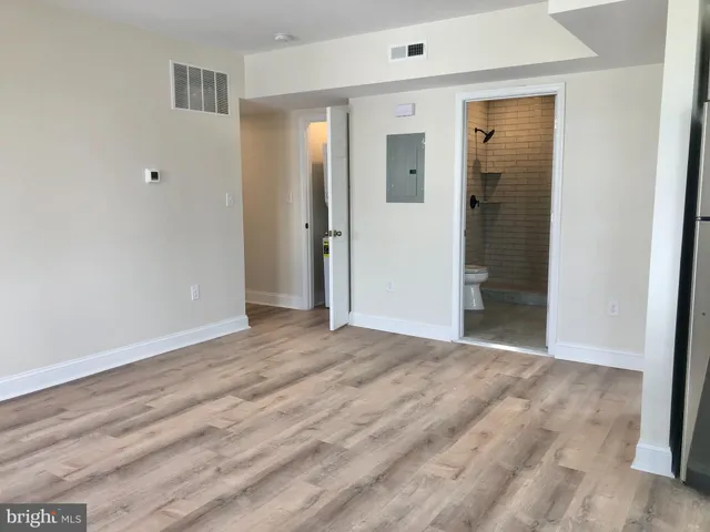 a view of an empty room with wooden floor