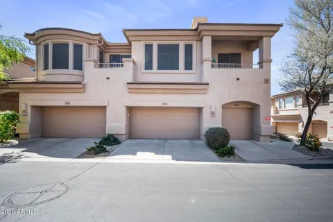 a front view of a house with yard and parking