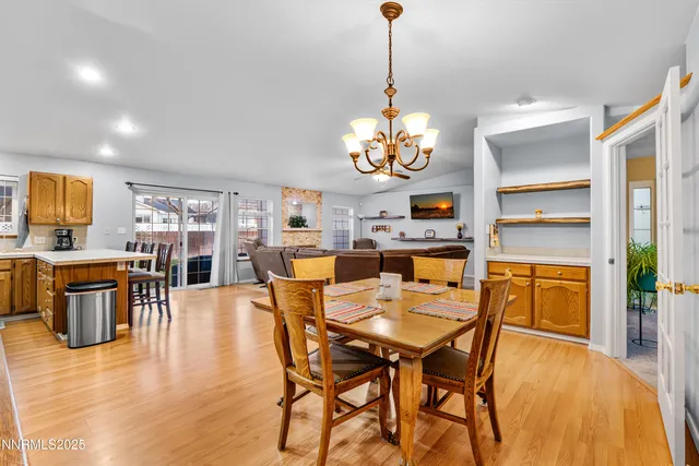 a view of a dining room with furniture a chandelier and wooden floor