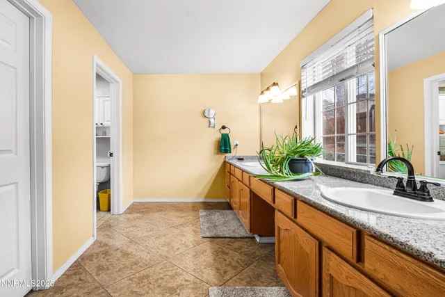a bathroom with a granite countertop sink a mirror and a shower