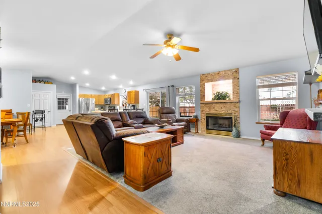 a living room with fireplace furniture and a open kitchen view