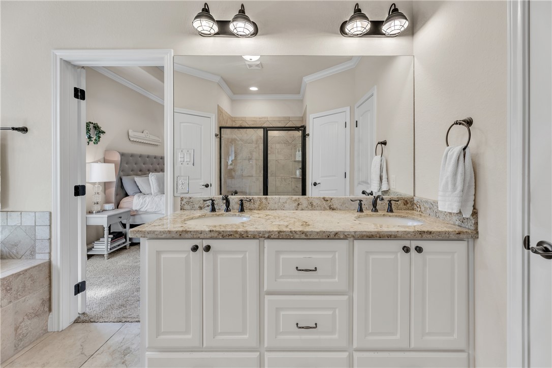 8312 Raintree Drive College Station, TX 77845 - Photo 17 of 30 Double vanity with light-toned countertop, dual undermount sinks, and industrial-style lighting fixtures