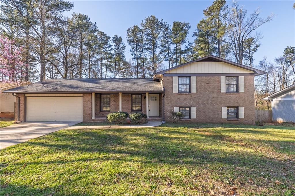 a front view of a house with a yard and trees