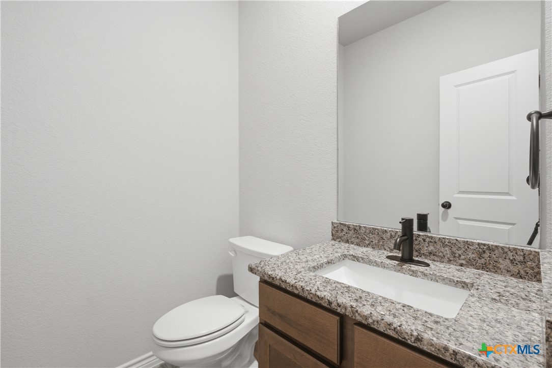 3201 Hedwig Street Killeen, TX 76549 - Photo 22 of 38 a bathroom with a granite countertop toilet sink and mirror