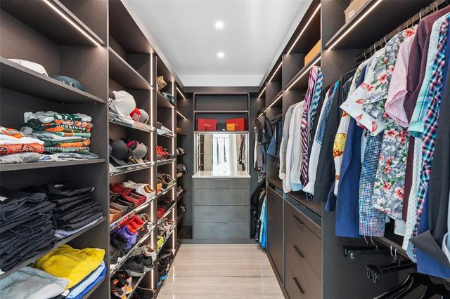 a living room with furniture a flat screen tv and floor to ceiling window