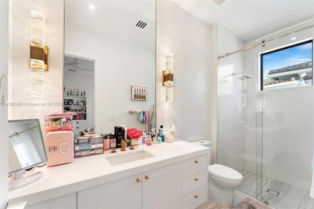 a view of a house in front of a big yard with potted plants