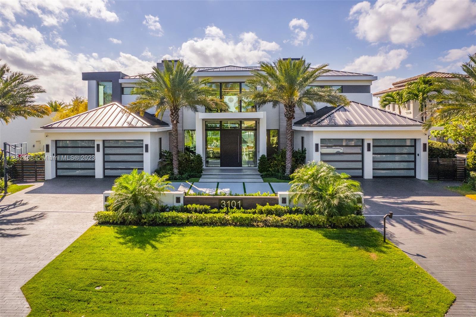 3101 Northeast 27th Avenue Lighthouse Point, FL 33064 - Photo 70 of 78 a front view of a house with a garden and fountain