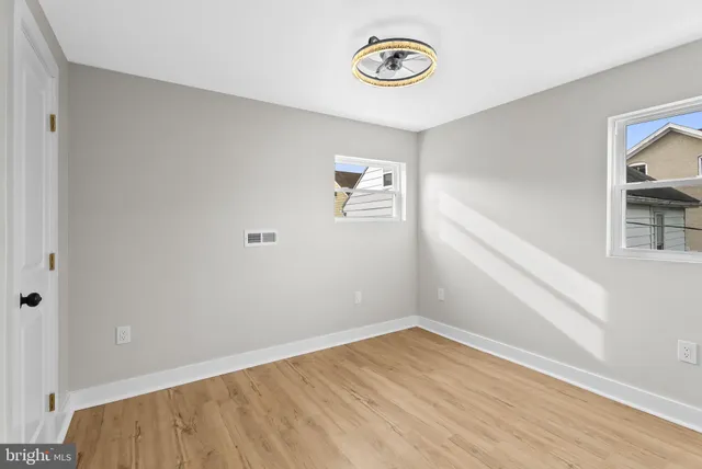 an empty room with a window and wooden floor