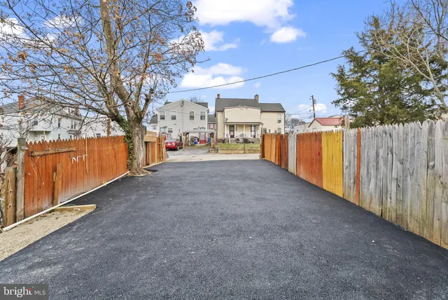 a view of a backyard with wooden fence