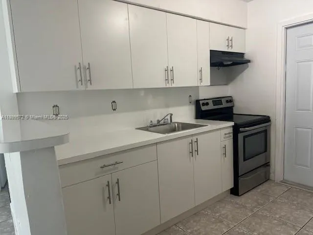 a kitchen with white cabinets and white appliances