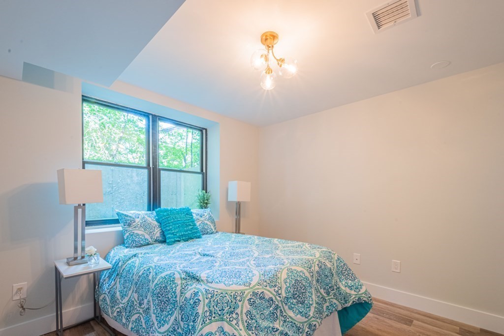 5 Kimball Road Lexington, MA 02421 - Photo 38 of 42 a bedroom with a bed and a chandelier