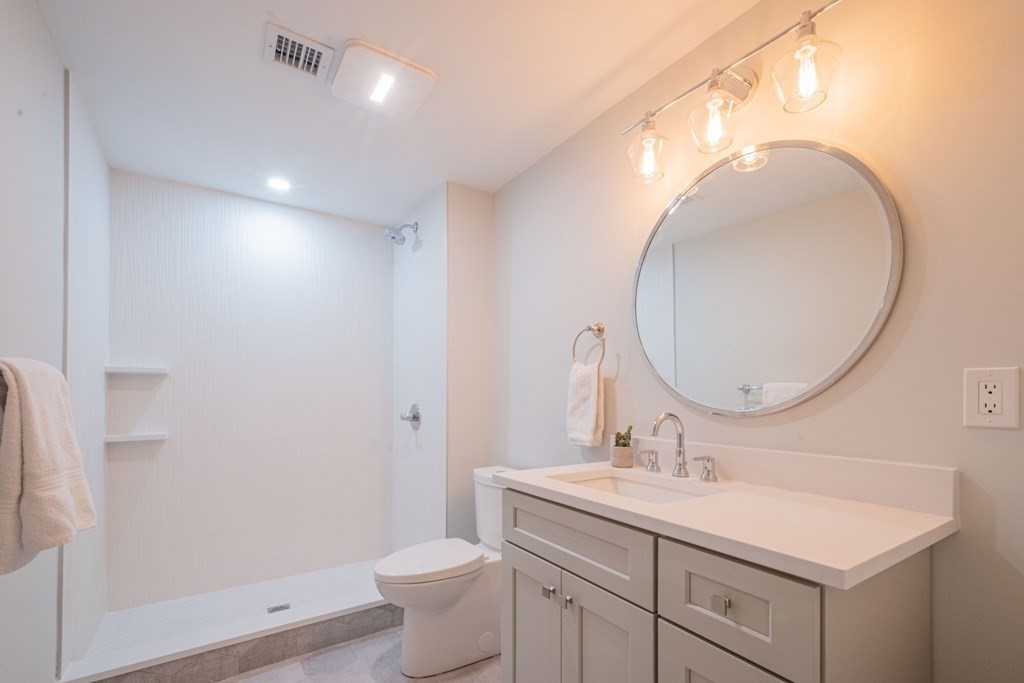 5 Kimball Road Lexington, MA 02421 - Photo 39 of 42 a bathroom with a toilet a sink a mirror and vanity
