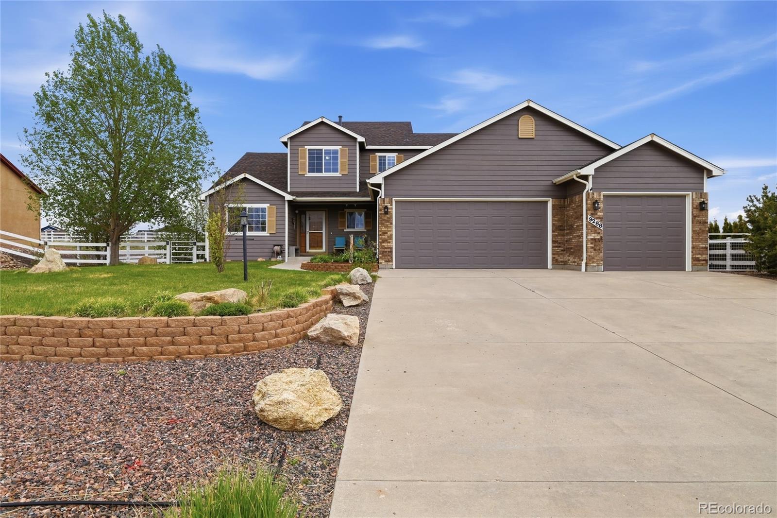 9288 Rockingham Drive Peyton, CO 80831 - Photo 3 of 49 a front view of a house with a yard and garage