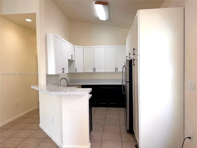 a kitchen with a refrigerator sink and cabinets