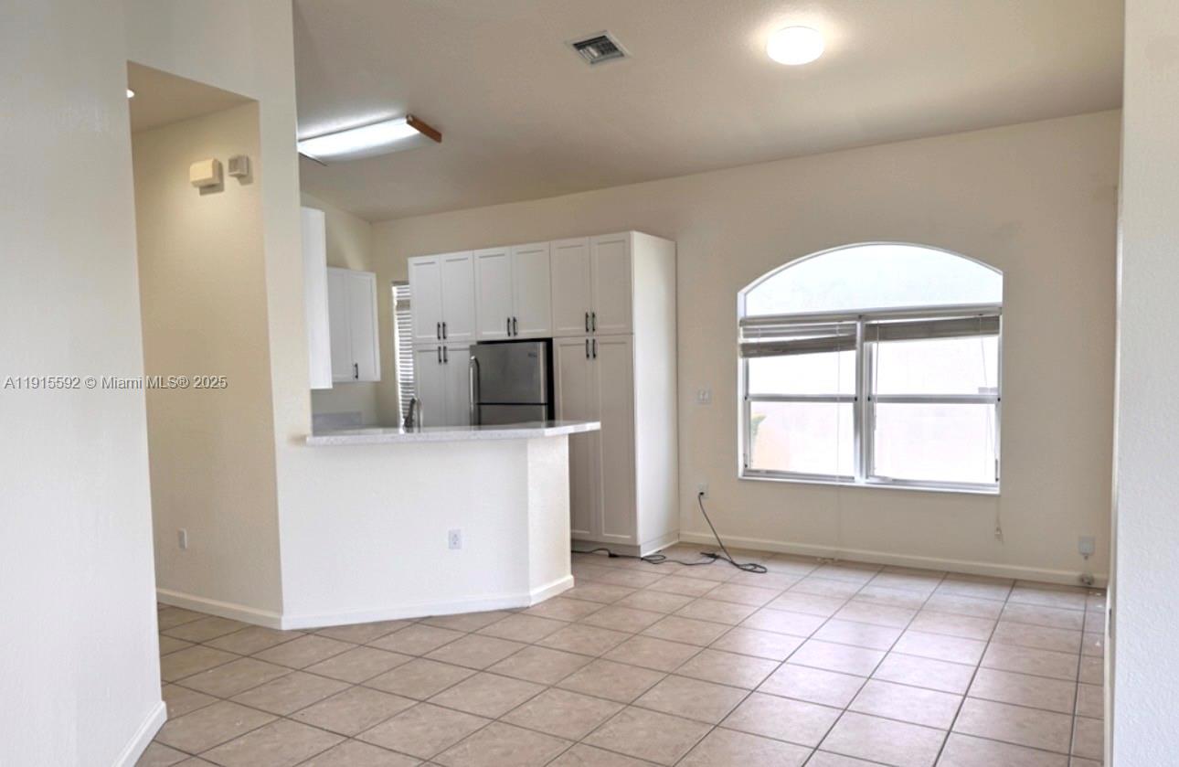 3725 Northeast 23rd Court Homestead, FL 33033 - Photo 8 of 25 a view of a kitchen and a windows and a refrigerator