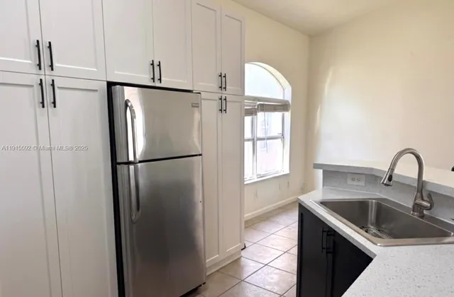 a kitchen with a refrigerator and a stove top oven