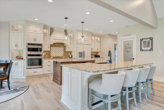 a kitchen that has a lot of cabinets in it and wooden floors