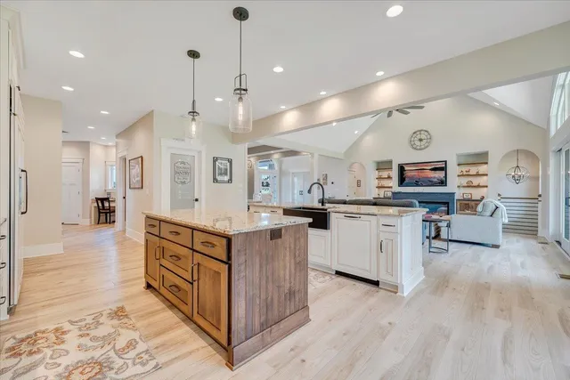 a view of a hallway with wooden floor and a bathroom