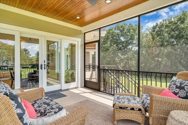 a view of a hallway with wooden floor and a bathroom