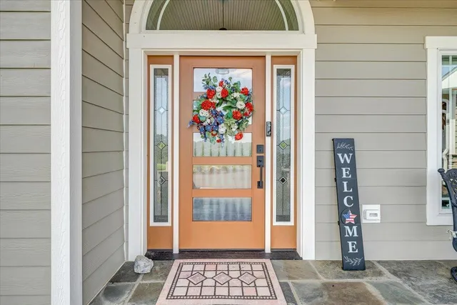 a dining room with wooden floor a chandelier a glass table and chairs