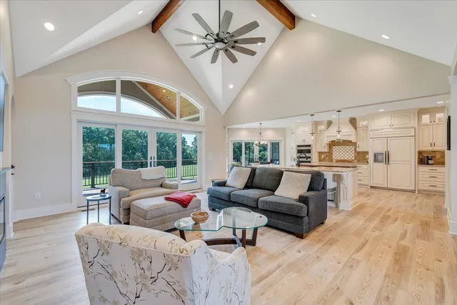 a kitchen with stainless steel appliances kitchen island granite countertop a stove a refrigerator and white cabinets with wooden floor