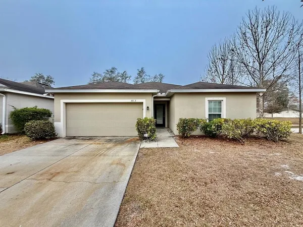 a view of a house with a yard and garage