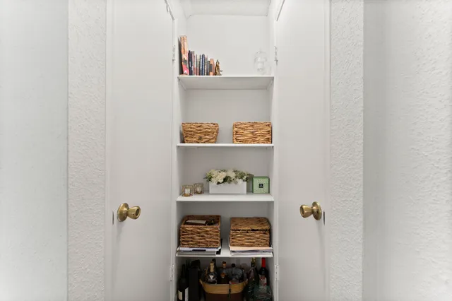 a table with a painting on the wall and a wooden floor