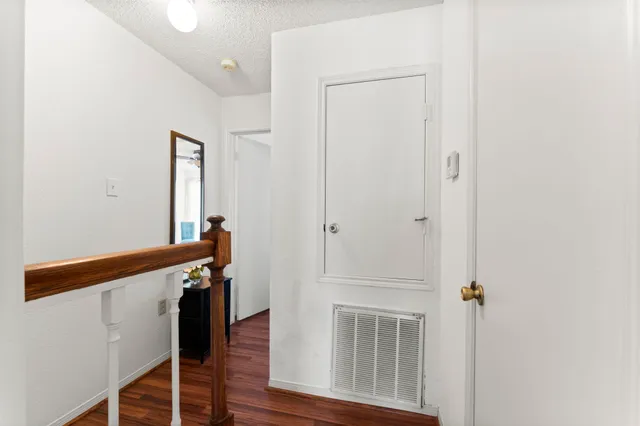 a view of a hallway with wooden floor and staircase