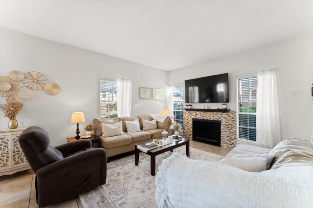a living room with furniture a fireplace and a flat screen tv