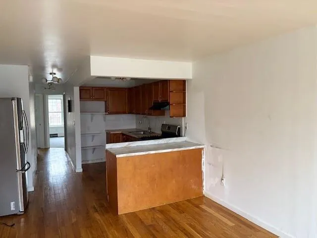 a view of a kitchen with wooden floor and a sink