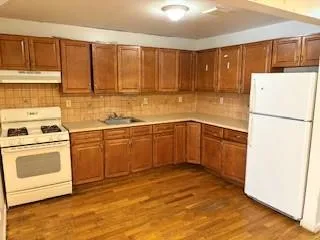 a view of a room with wooden floor and brick walls