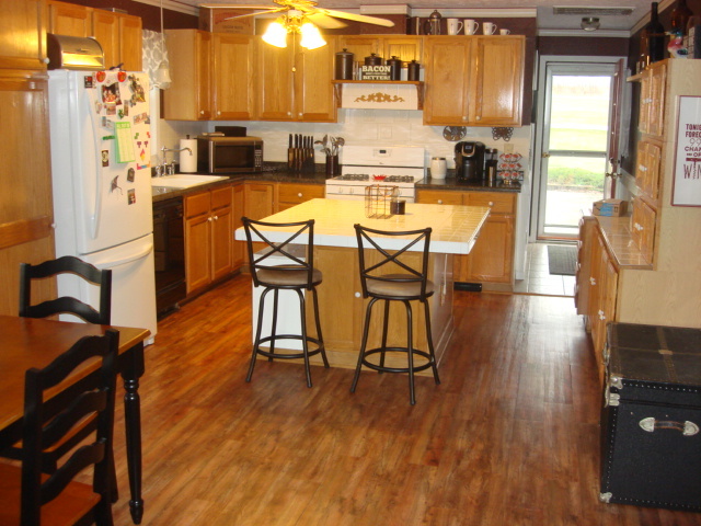 2387 North 24th Road Marseilles, IL 61341 - Photo 6 of 23 a kitchen with stainless steel appliances a refrigerator a stove a dining table and chairs with wooden floor
