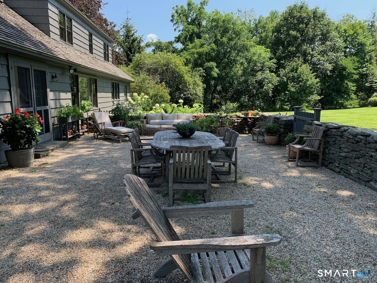 87 Beaver Dam Road Salisbury, CT 06068 - Photo 7 of 35 a view of a patio with table and chairs potted plants and a large tree