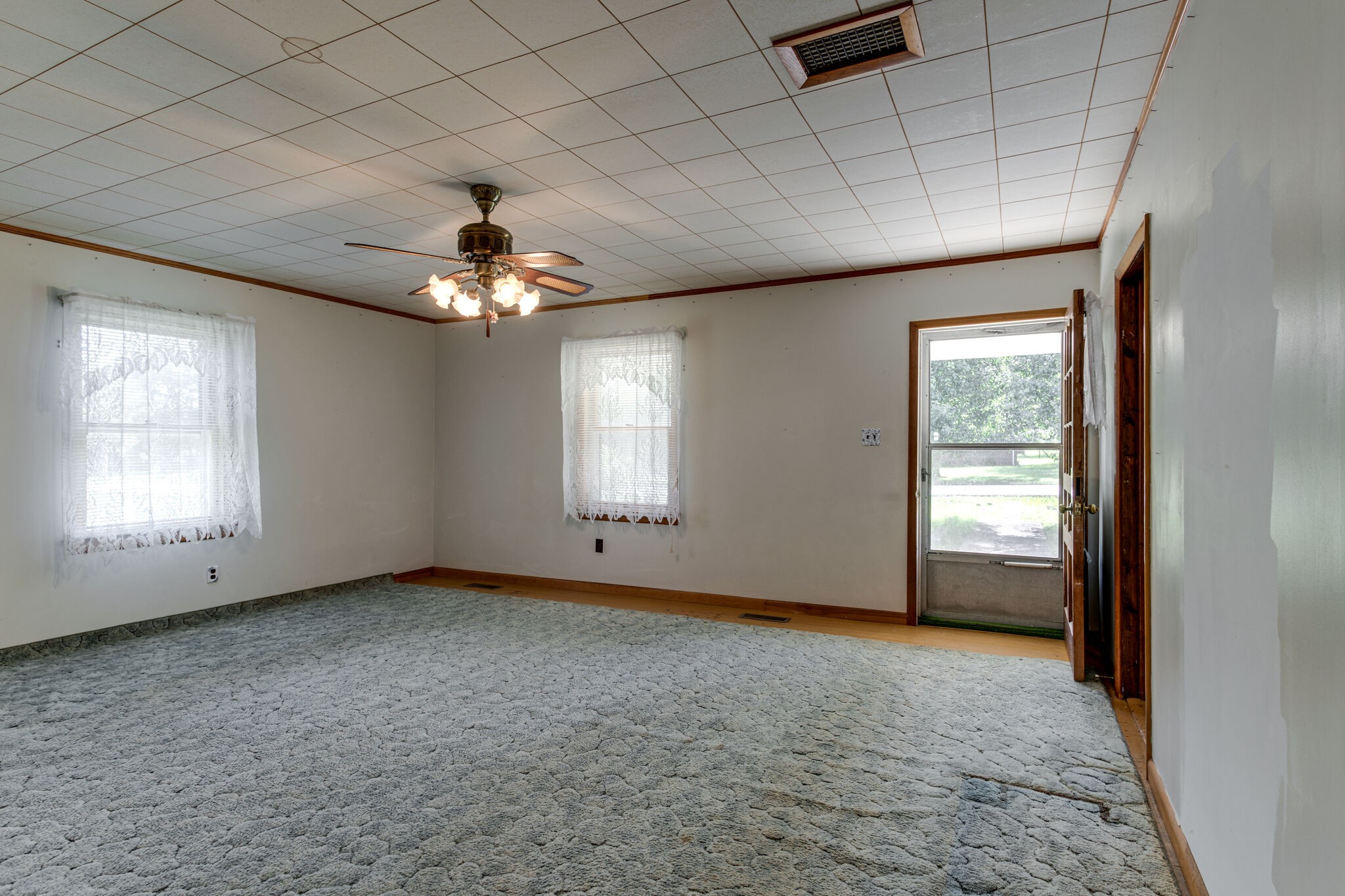 9188 Versailles Road Rockvale, TN 37153 - Photo 4 of 25 an empty room with chandelier fan and windows