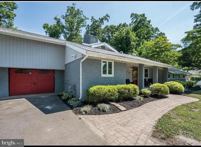 a front view of a house with a yard and potted plants