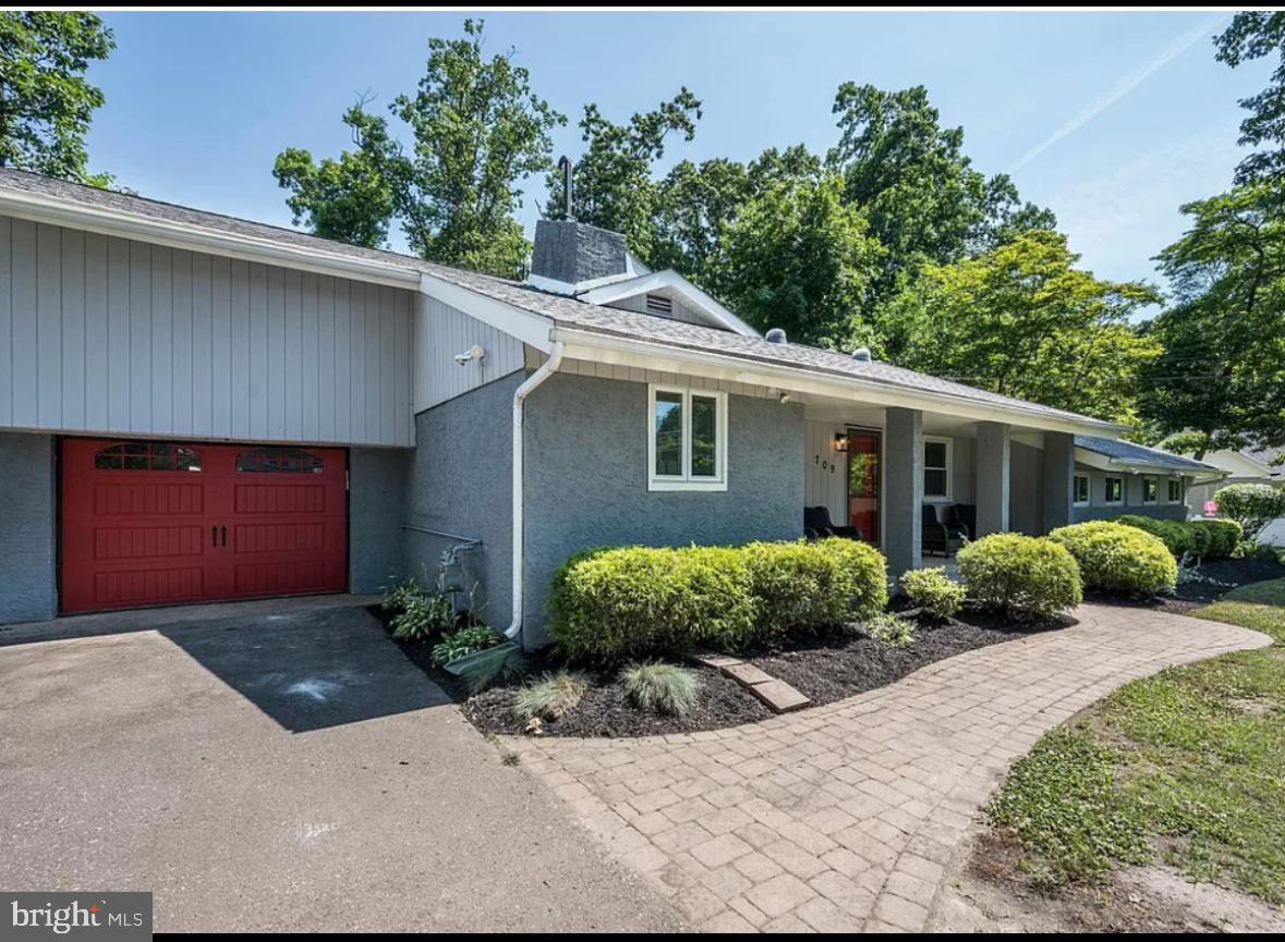 a front view of a house with a yard and potted plants