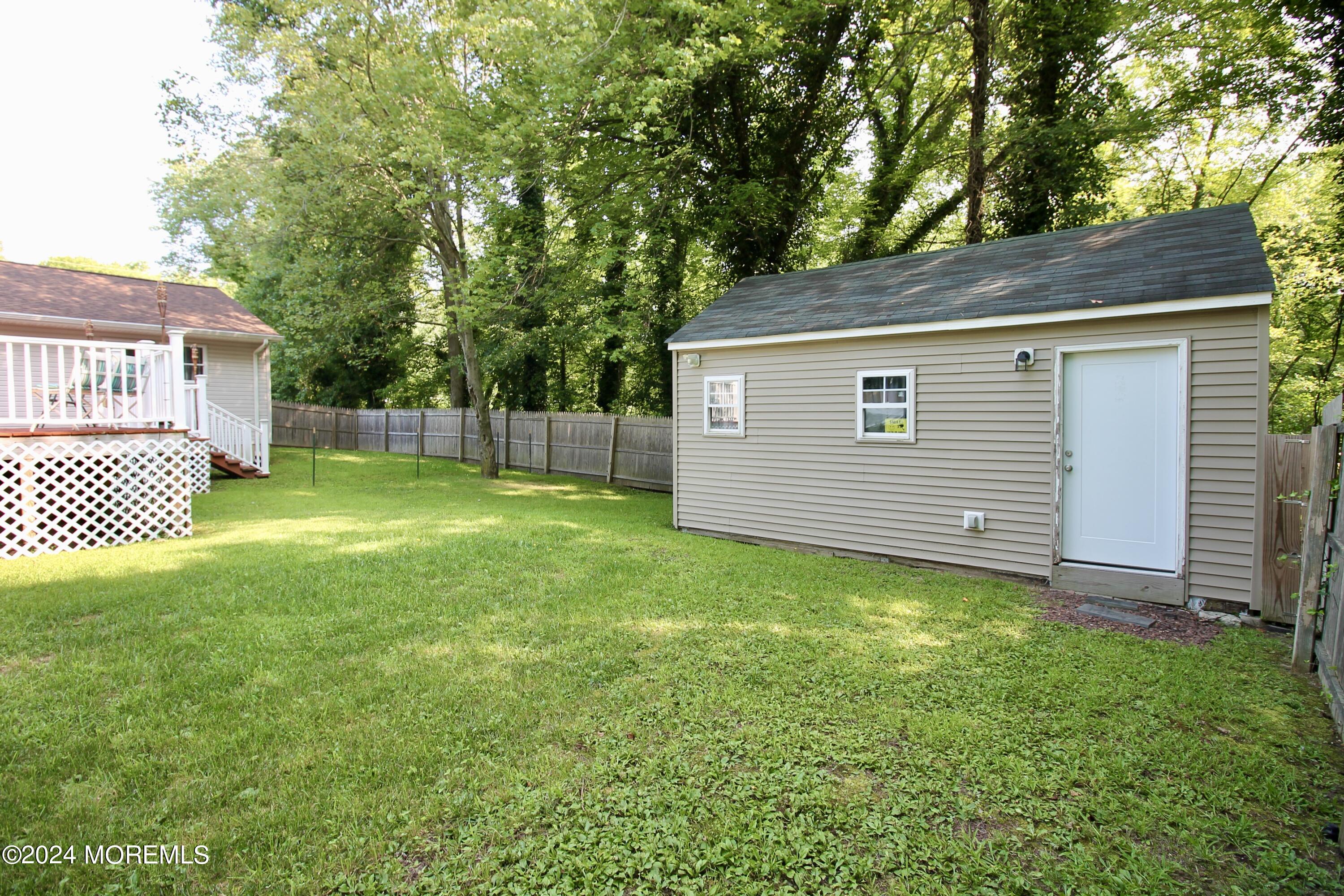 877 Monmouth Road Cream Ridge, NJ 08514 - Photo 54 of 58 a backyard of a house with lawn chairs and a large tree