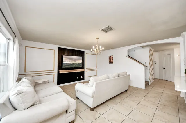 a living room with furniture and a chandelier