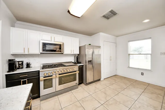 a kitchen with stainless steel appliances granite countertop a sink a stove and a refrigerator