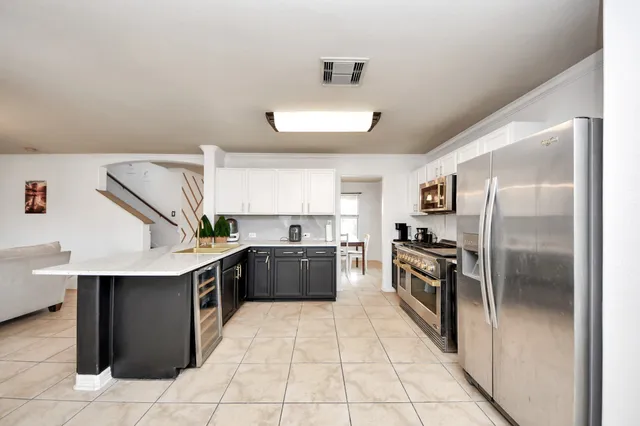 a kitchen with stainless steel appliances kitchen island granite countertop a refrigerator and a sink
