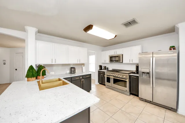 a spacious bedroom with a bed and a flat screen tv