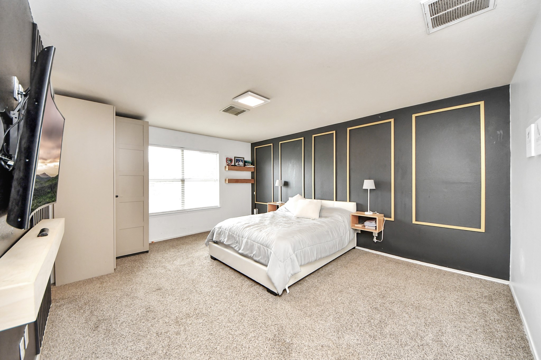 611 Remwick Drive Houston, TX 77073 - Photo 23 of 42 a spacious bedroom with a bed and a flat screen tv
