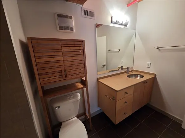 a bathroom with a sink toilet and mirror